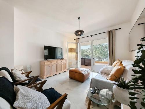 a living room with a couch and a tv at Sea View - Pool view - Beach Front - 25 meter to beach in Málaga