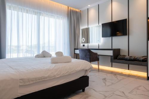 a bedroom with a bed and a flat screen tv at Oros Paradise Hotel in Pastida