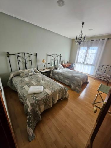 two beds in a large room with wooden floors at MEQUEDO el ESPOLON in Alcañiz
