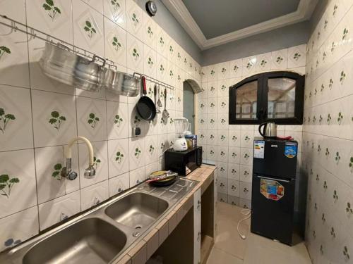 a kitchen with a sink and a refrigerator at Jfk3 in Ouagadougou