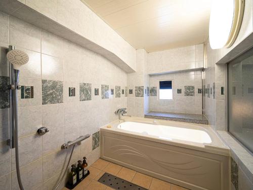 a bathroom with a tub and a window at HOTEL U's 香櫨園 Adult Only 阪神西宮 in Nishinomiya