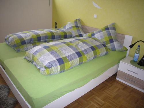 un letto verde con due cuscini sopra di Ferienwohnung Keull a Coesfeld