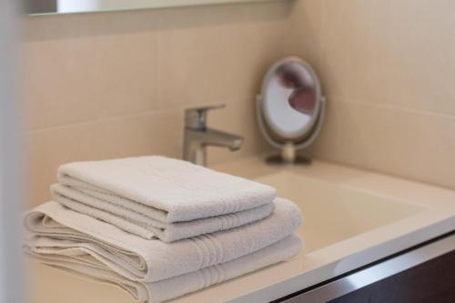 a pile of towels sitting on a bathroom sink at La tour du manoir in Arouille