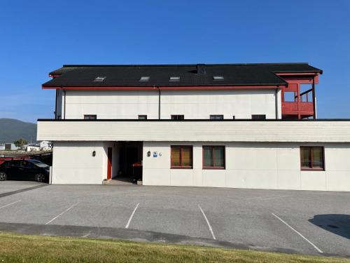 a large white building with a parking lot at Beautiful panoramic apartment in Vestnes
