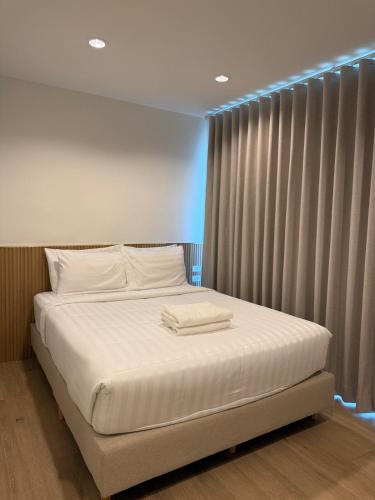 a bed with two towels on it in a room at 2 Bed & 2 Bath Suite, 4th floor in Ban Bang Toei (1)