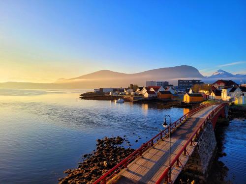 a town on the water with mountains in the background at Beautiful panoramic apartment in Vestnes