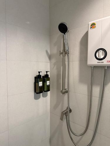 a shower in a bathroom with two soap bottles at 2 Bed & 2 Bath Suite, 4th floor in Ban Bang Toei (1)