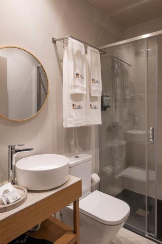 a bathroom with a toilet and a sink and a shower at A Casita Clara in Amarante