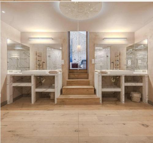 a bathroom with two sinks and two mirrors at Mas de Bubu in Châteaurenard