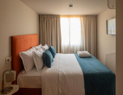 a bedroom with a bed with pillows and a window at A Casita Clara in Amarante