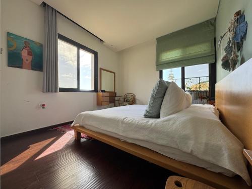 a bedroom with a large white bed with a window at Batroun Escape, 2BR, 24-7 elect, beach view! in Batroûn