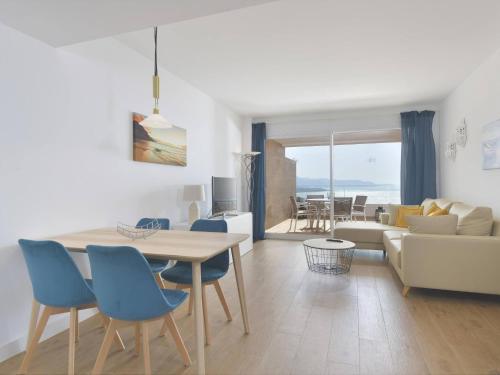 a living room with a table and blue chairs at Apartamento de lujo vista mar en Torrox Costa in Torrox Costa