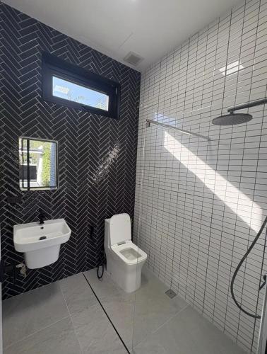 a bathroom with a toilet and a sink at Noir Blanc Modern Villa in Ko Phangan