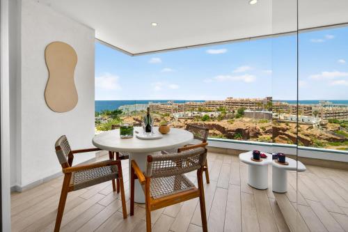 a dining room with a table and chairs and a large window at OCEAN GARDEN Sunset & Sunrise - heated pool - AC - lounge zone in Adeje