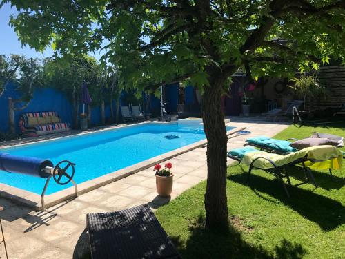 a swimming pool with a tree in a yard at Les Poiriers Rouges in Mauchamps