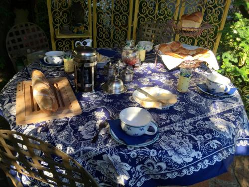 a table with a blue and white table cloth with bread at Les Poiriers Rouges in Mauchamps