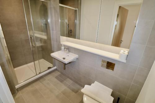 a bathroom with a toilet and a shower and a sink at Chertsey Modern 2-Bed Flat with Parking in Chertsey