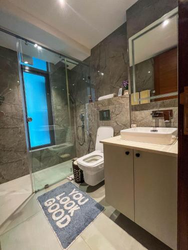 a bathroom with a shower and a toilet and a sink at Solaris Executive Suites Osu Pool Gym in Accra