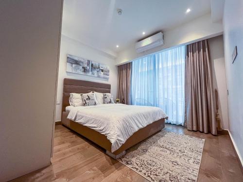 a bedroom with a bed and a large window at Solaris Executive Suites Osu Pool Gym in Accra