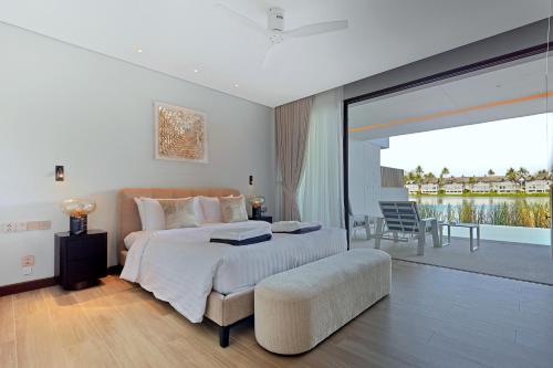 a bedroom with a large bed and a balcony at Laguna luxury apartment - Bang Tao - lake view in Bang Tao Beach