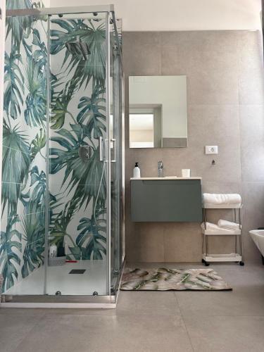 a bathroom with a shower with a sink and a mirror at Le Palme - Holiday Home in Brindisi