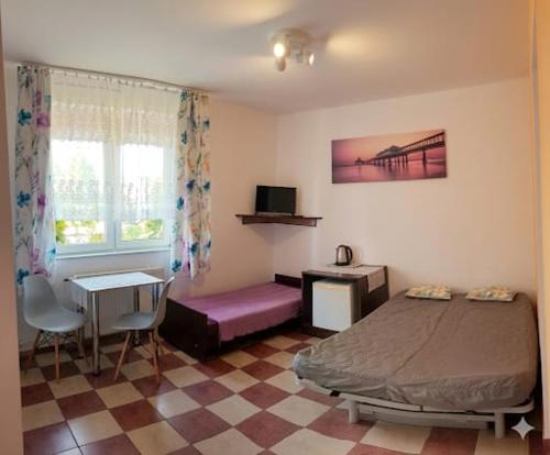 a bedroom with a bed and a table and a desk at Idylla in Chłopy