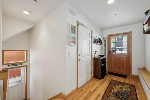 a hallway with white walls and a wooden door at Cozy Hillside Cottage Overlooking Main Street in Park City