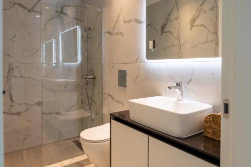 a bathroom with a sink and a toilet and a shower at Oros Paradise Hotel in Pastida