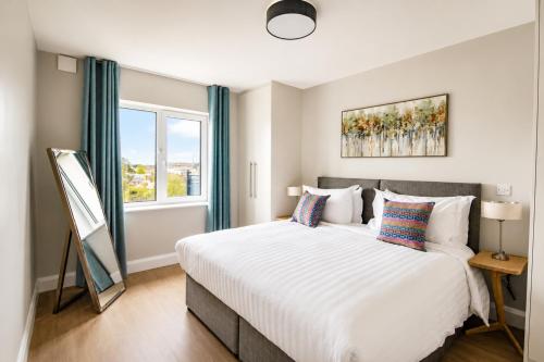 a bedroom with a large white bed and a window at The Maltings in Portlaoise