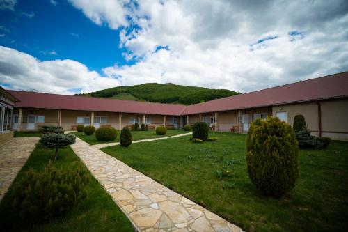 a building with a grass yard in front of it at Hotel Sjever in Šavnik