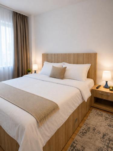 a bedroom with a large bed with white sheets at Adrian Home Libra in Ploieşti
