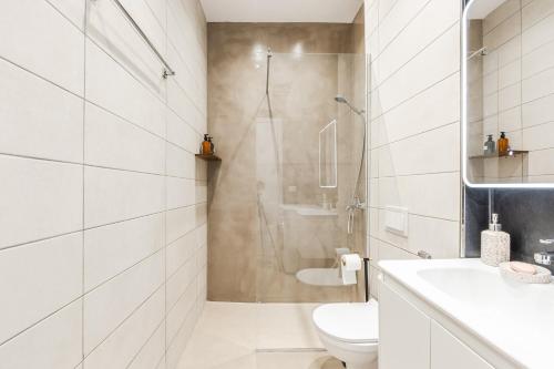 a white bathroom with a shower and a toilet at NooN Properties Santorini by PikHost in Palasë