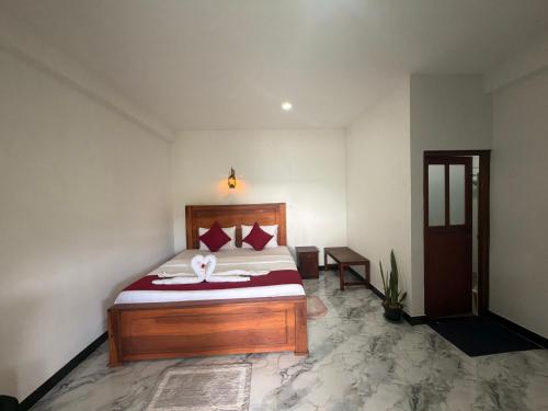 a bedroom with a bed with red pillows at Duo Haven Inn Ella in Ella