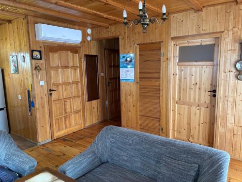 a living room with a couch and wooden walls at Alga in Mrzeżyno