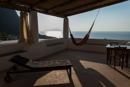 a room with a hammock and a view of the ocean at Hotel La Locanda Del Postino in Pollara