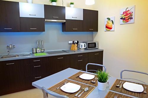 a kitchen with a table and a sink and cabinets at Greyhouse in Jaworzno