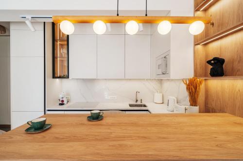 a kitchen with a wooden table with two cups on it at Boho Apartment with Sea View & Pool in Baošići