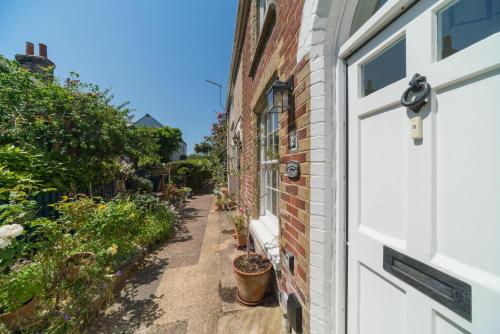 a door to a brick house with plants on the side at Christmas Cottage in Yarmouth