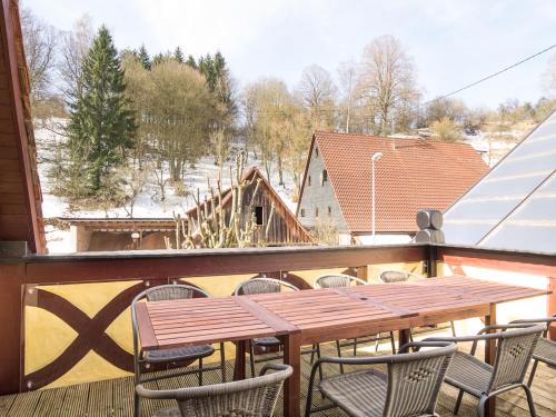 a wooden table and chairs on a balcony at Ferienhof Hohe in Hiltpoltstein