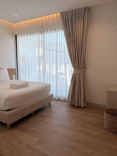 a bedroom with a bed and a large window at 2 Bed & 2 Bath Suite, 5th floor in Ban Bang Toei (1)