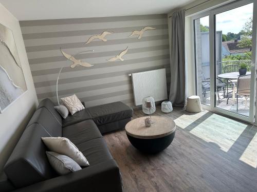 a living room with a couch and a table at Eastside 2 am Kurpark in Scharbeutz