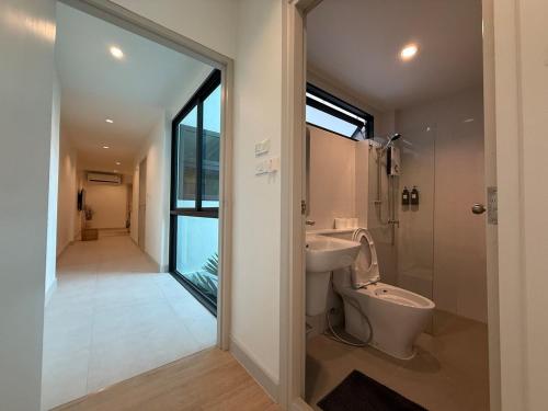 a bathroom with a toilet and a sink and a mirror at 2 Bed & 2 Bath Suite, 5th floor in Ban Bang Toei (1)