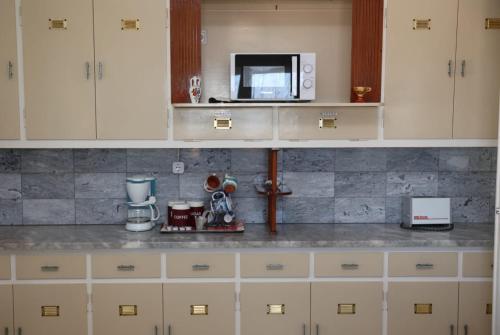 a kitchen with white cabinets and a microwave at Sea view apartment in Plomari