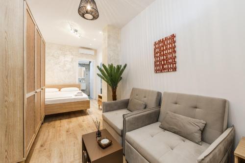 a living room with a couch and a bed at NooN Properties Santorini by PikHost in Palasë