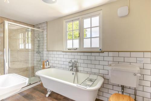 a bathroom with a tub and a toilet and a sink at 2 Bed in Minehead oc-77363 in Withypool