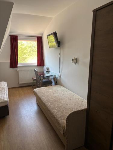 a bedroom with a bed and a table and a window at Zátonyi Csárda Panzió in Dunasziget