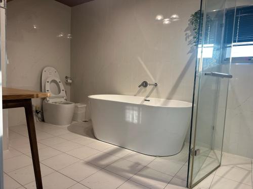 a bathroom with a bath tub and a toilet at 上水民宿 in Chiayi City