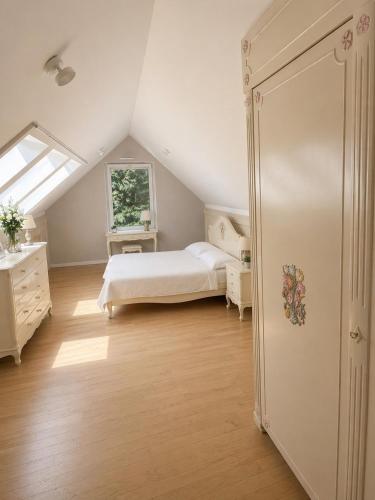 a attic bedroom with a bed and a window at Prestige Garden Villa - Cracow in Krakow