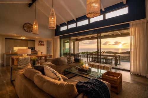 a living room with couches and a view of the ocean at Peninsula Villa - Romansbaai in Gansbaai