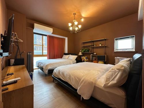 a bedroom with two beds and a desk at 上水民宿 in Chiayi City